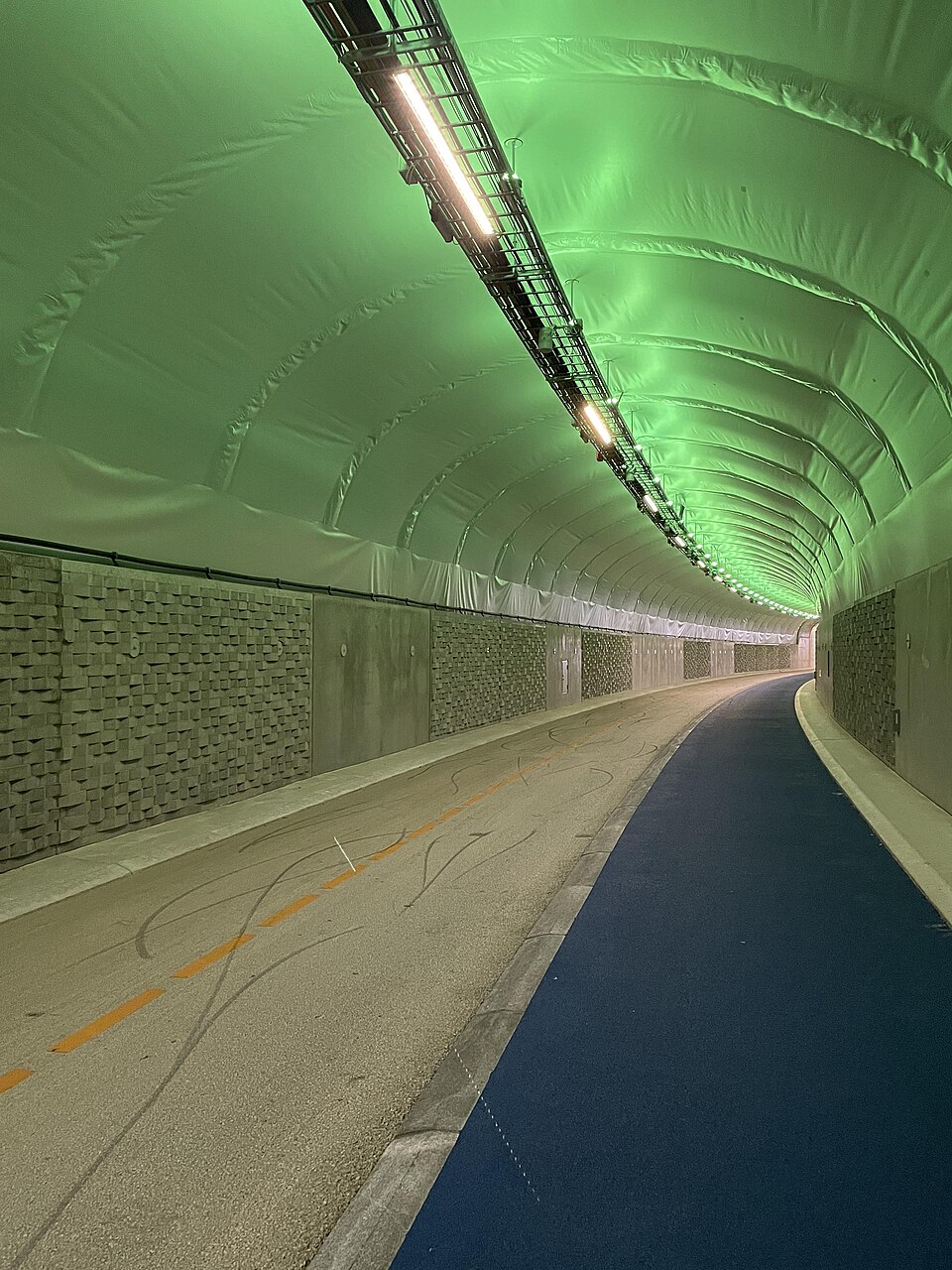 Inside the Fyllingsdalstunnelen in Bergen: bike path and pedestrian corridor under colourful lighting